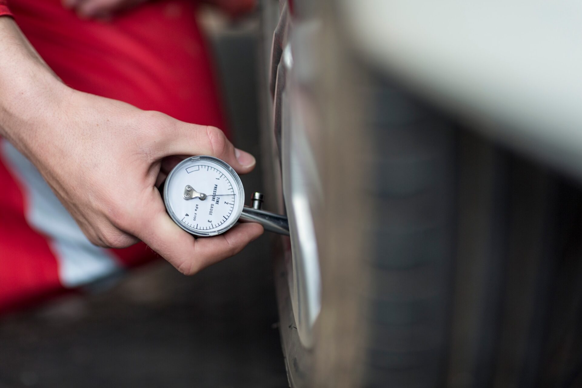 Mécanicien automobile au travail dans réparation garage, mange de pression des pneus